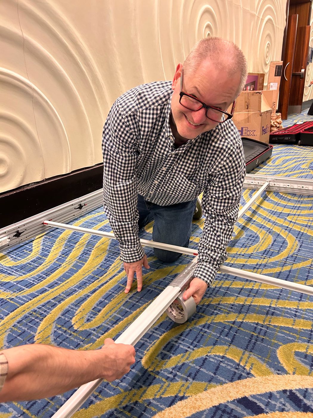 Team member applying duct tape to the booth frame